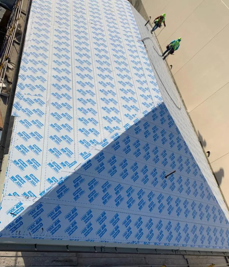 Professional roofers installing underlayment on a metal roof in Tuskegee